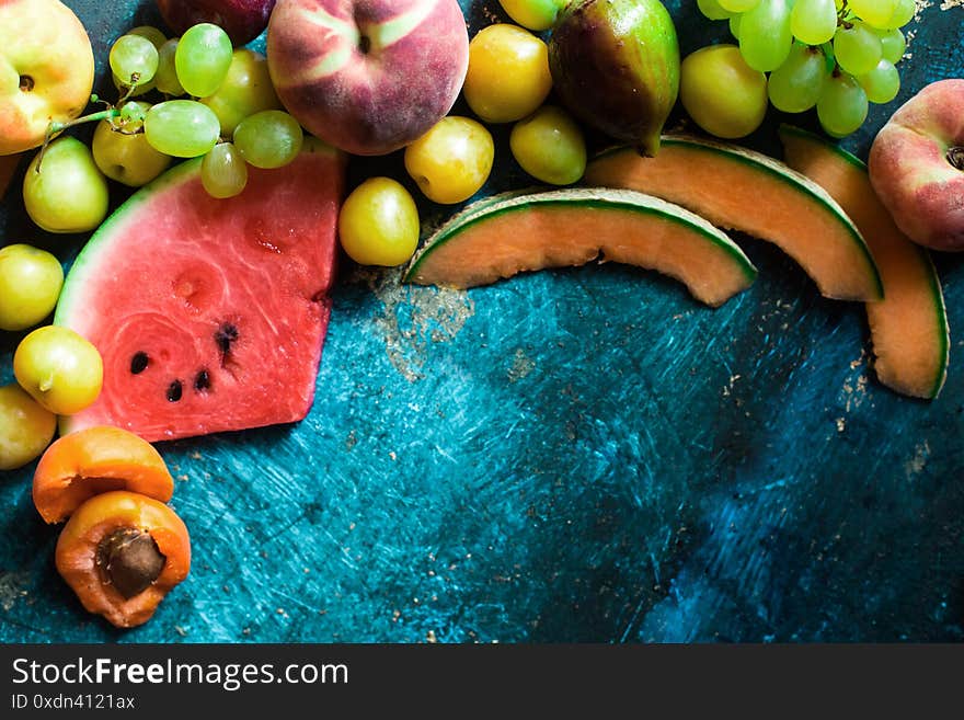 Ripe Summer fruits selection top view over blue rustic background