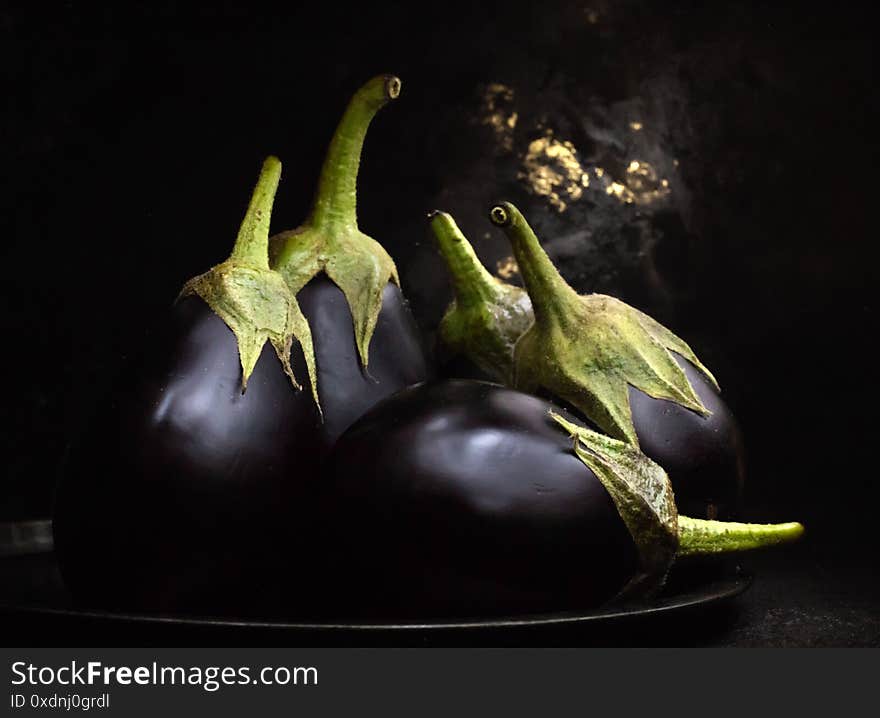 Biologic Raw Eggplants Over Black Bowl