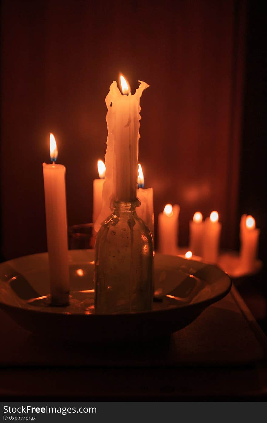 Still life with burning candles, a bottle and a basin. Romantic evening. Still life with burning candles, a bottle and a basin. Romantic evening.