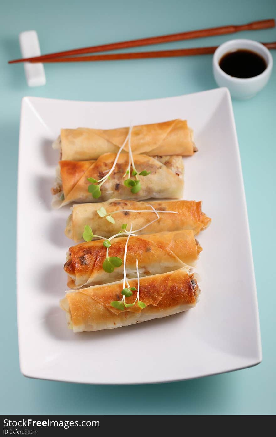 Spring rolls topped with sprouts and served with soy sauce. Spring rolls topped with sprouts and served with soy sauce