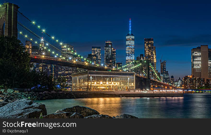 A beautiful blue sky covered over Brooklyn bridge, freedom tower and east river from the Brooklyn Bridge park. A beautiful blue sky covered over Brooklyn bridge, freedom tower and east river from the Brooklyn Bridge park.