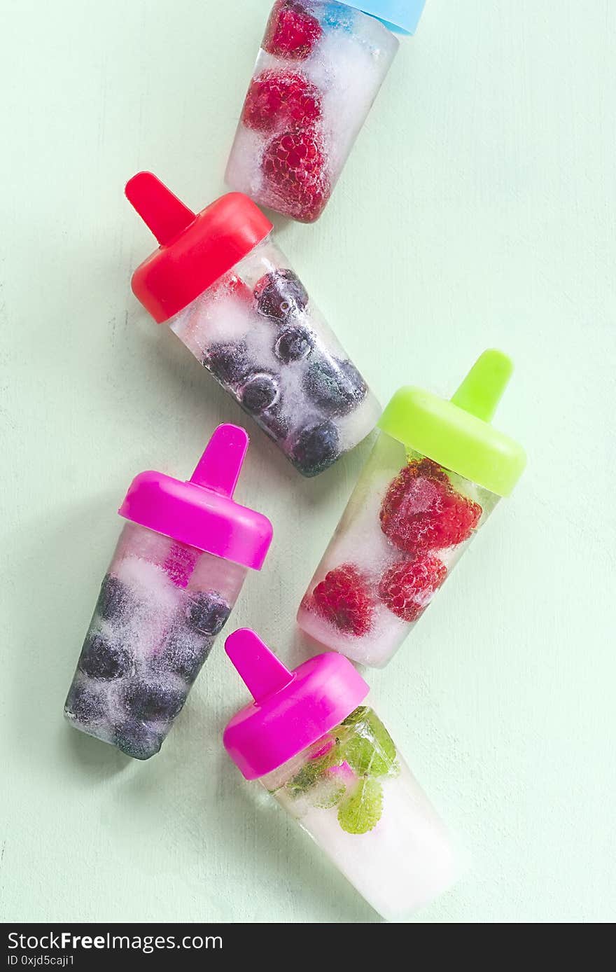 Berry Summer  Ice Lolly With Raspberries, Blueberries, Mint Leaves On A Green Mint Background