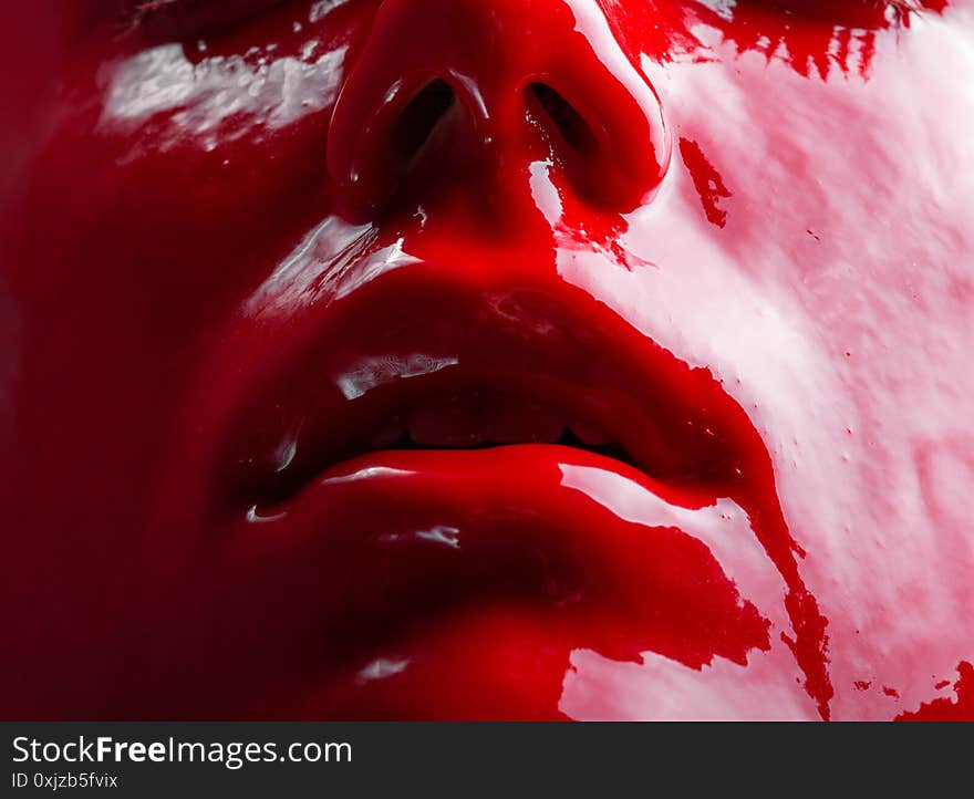 Photo of woman`s face with draining red paint, close-up. Photo of woman`s face with draining red paint, close-up