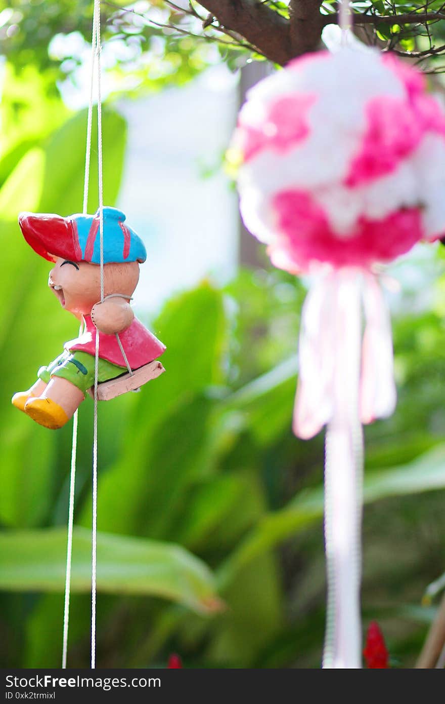 Artificial Pink Flowers Hanging And Clay Doll Decoration On Tree In Marriage. Wedding Decorative In The Green Garden.