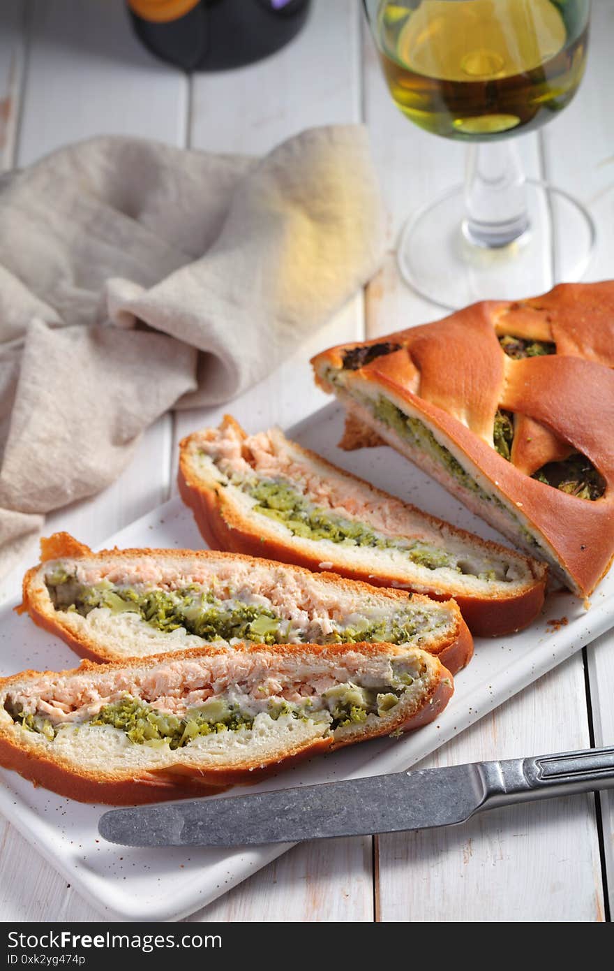 Sliced salmon and broccoli pie and a glass of white wine. Sliced salmon and broccoli pie and a glass of white wine