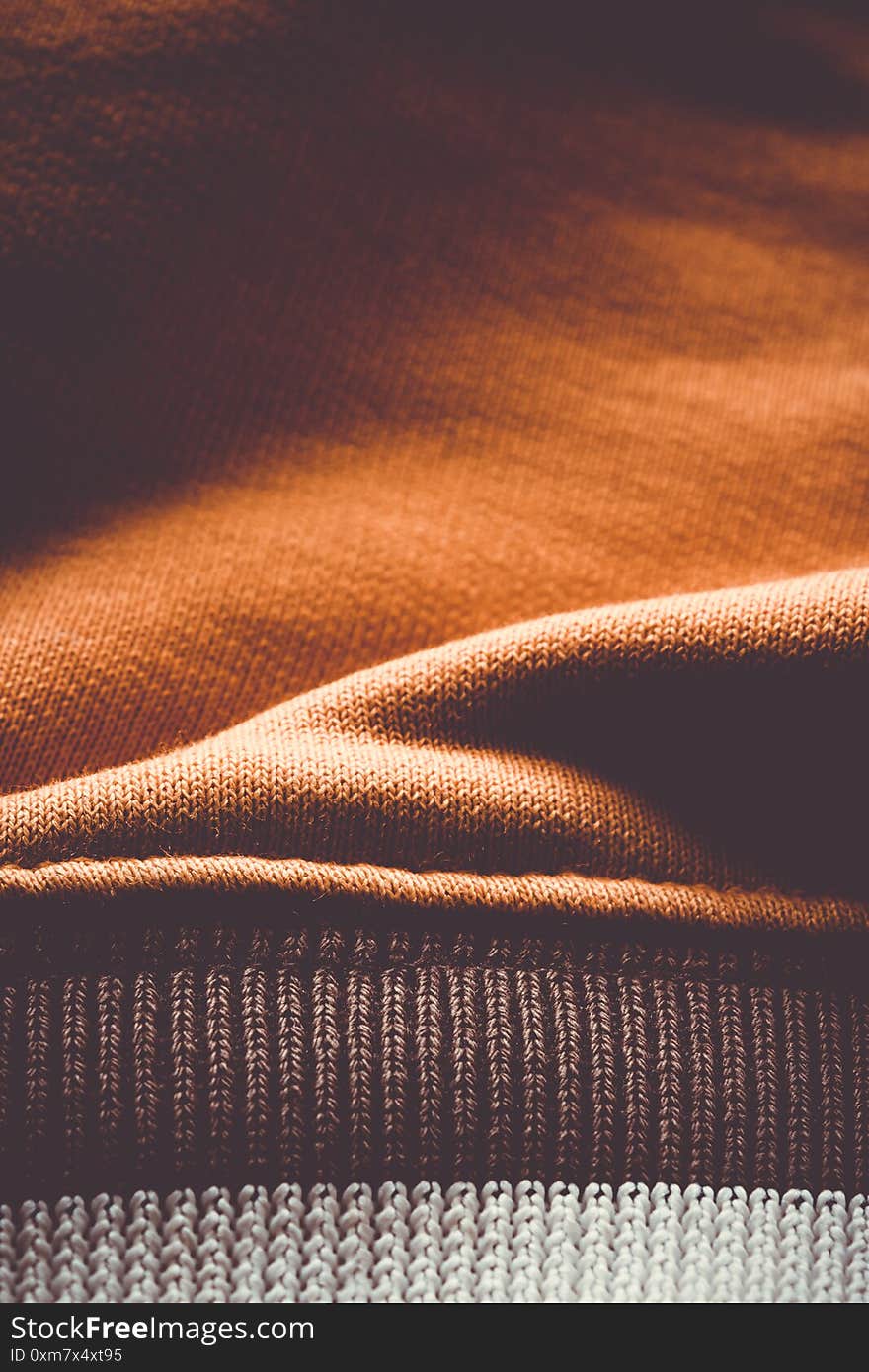 Vertical close-up to fabric of a orange blouse sleeve. Vertical close-up to fabric of a orange blouse sleeve