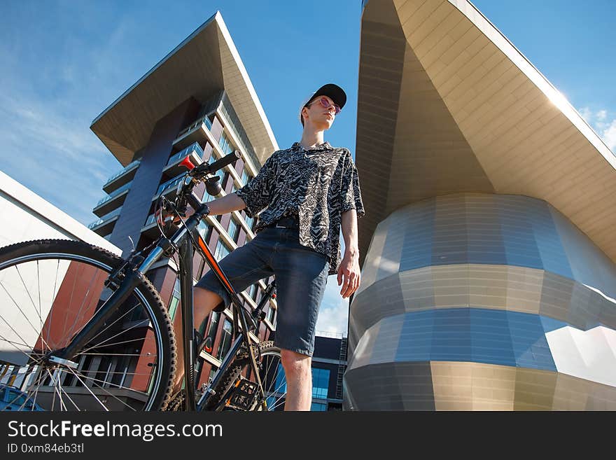 Hiker cyclist sitting on a bicycle. Biker stopped on a city street. Hiker cyclist sitting on a bicycle. Biker stopped on a city street