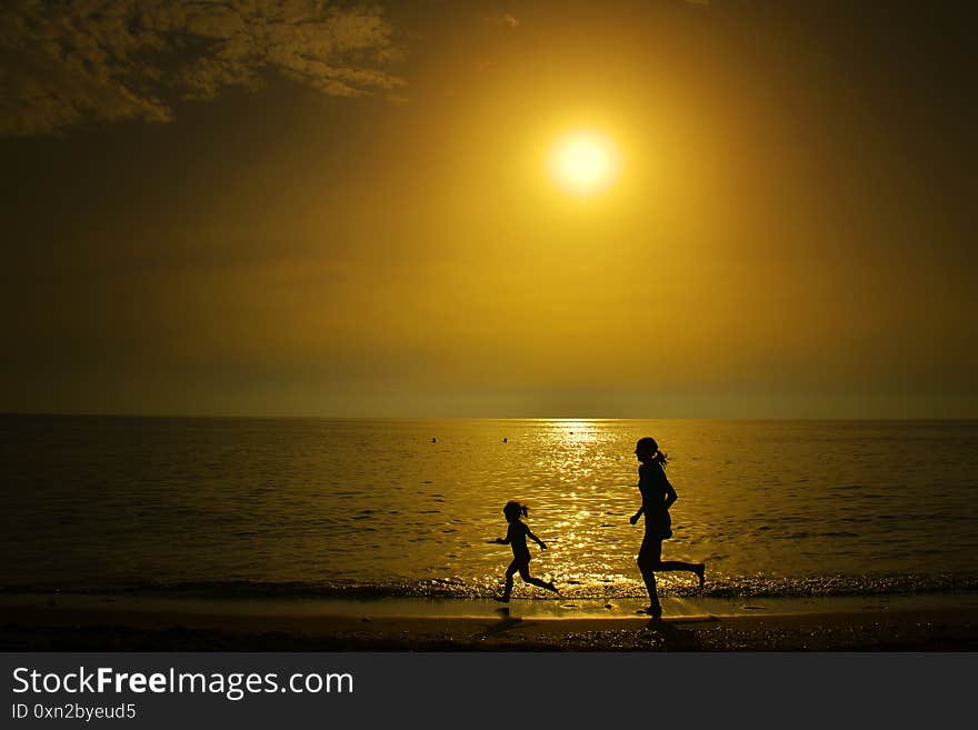 Woman and child silhouettes on a beach  in Corfu, Greece. Sea and yachts photography