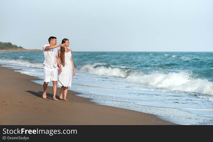 Loving couple on seaside in white dress,  honeymoon or  holiday - vacation concept