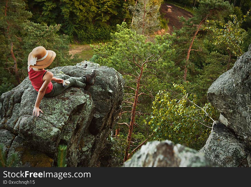 Young girl sitting on the peak of mountain. Young girl sitting on the peak of mountain