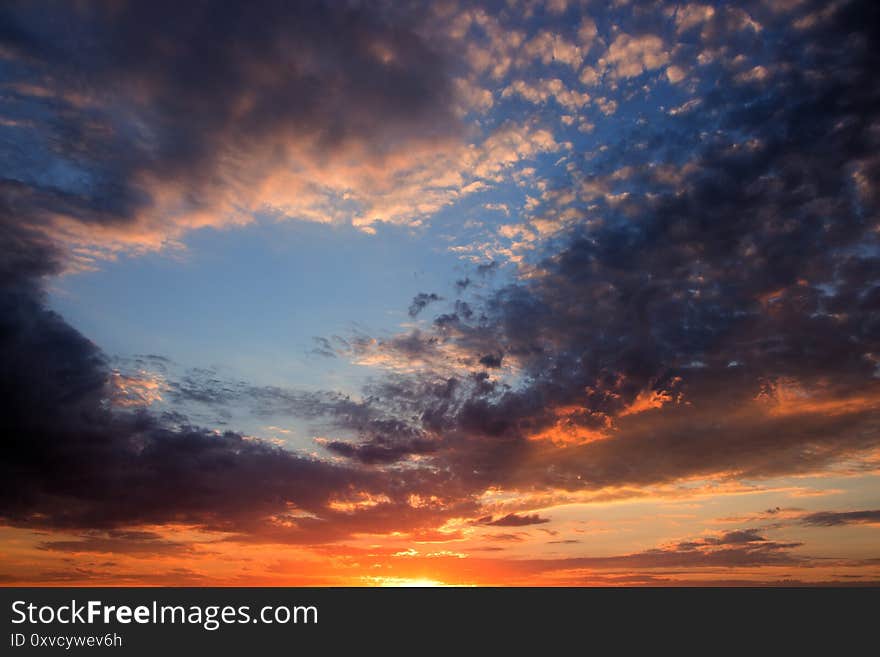 Sunset in the colorful clouds, orange and blue sky at sunset. Sunset in the colorful clouds, orange and blue sky at sunset