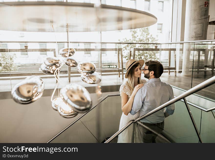 Stylish Couple Look At Each Other On Stairs In Restorant