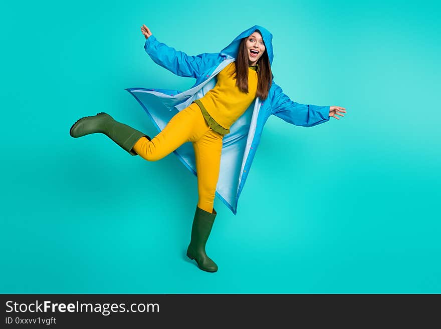 Full body photo of attractive funny lady cheerful mood rainy weather street walk hood on head many puddles raise leg