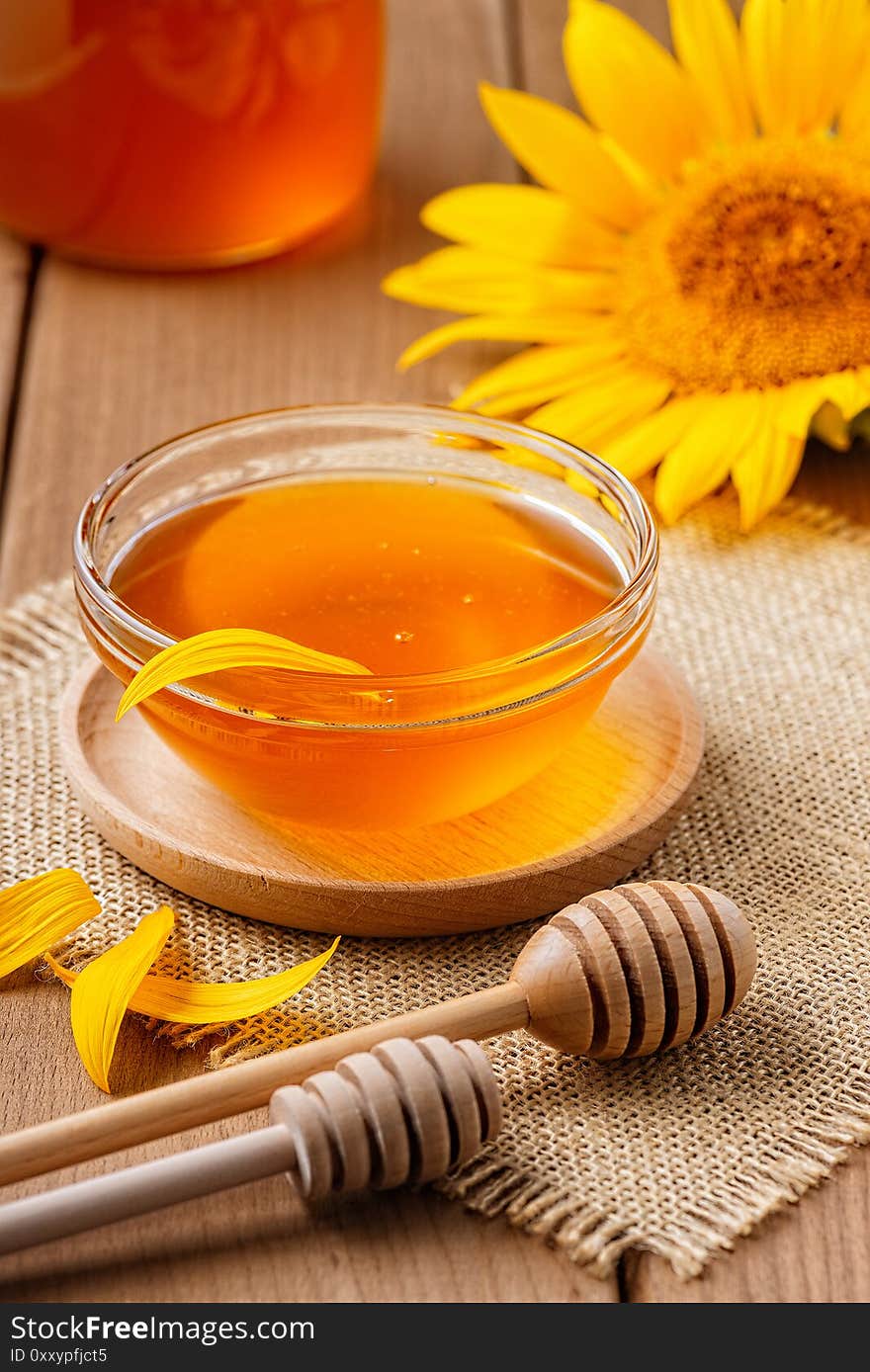 honey in a glass jar on a wooden table.