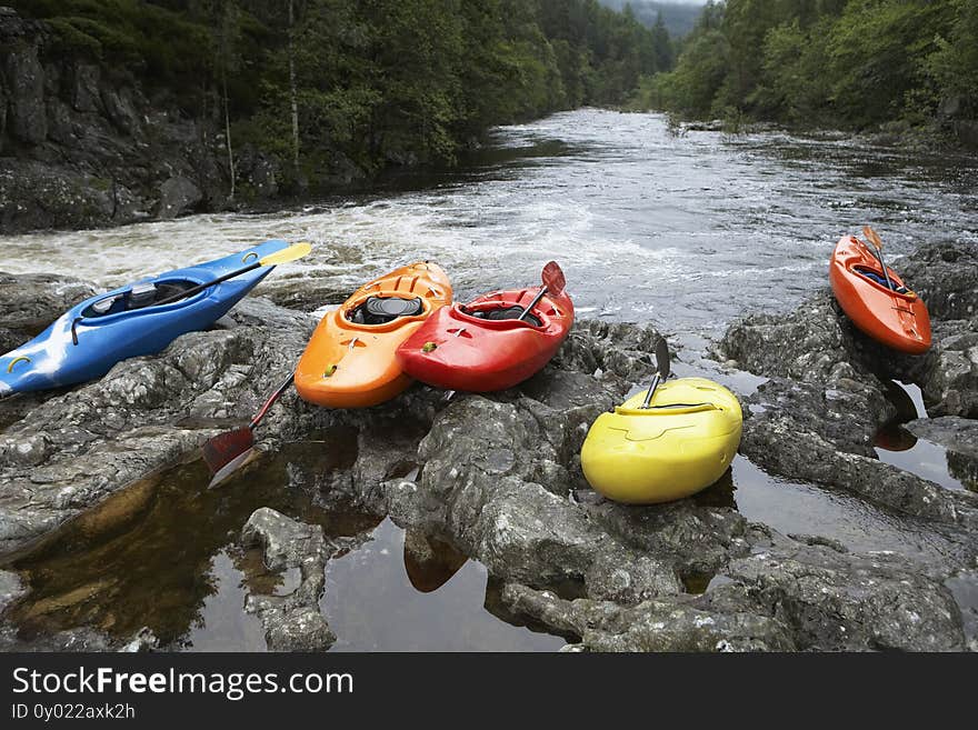 Portrait of Colourful kayaks by river