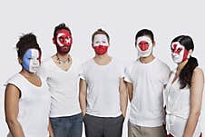 Portrait Of Serious Multi-ethnic Group Of Friends With Various National Flags Painted On Their Faces Standing Against White Backgr Royalty Free Stock Photography