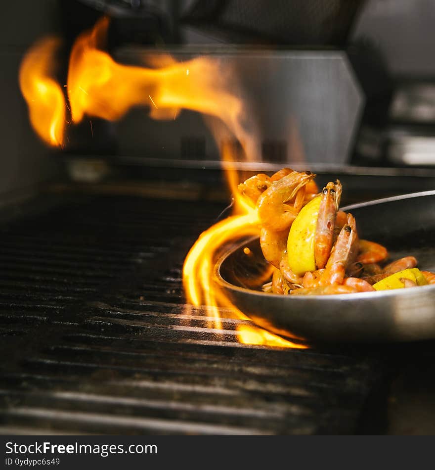 Closeup on cooking shrimps with lemon in a pan on the flame