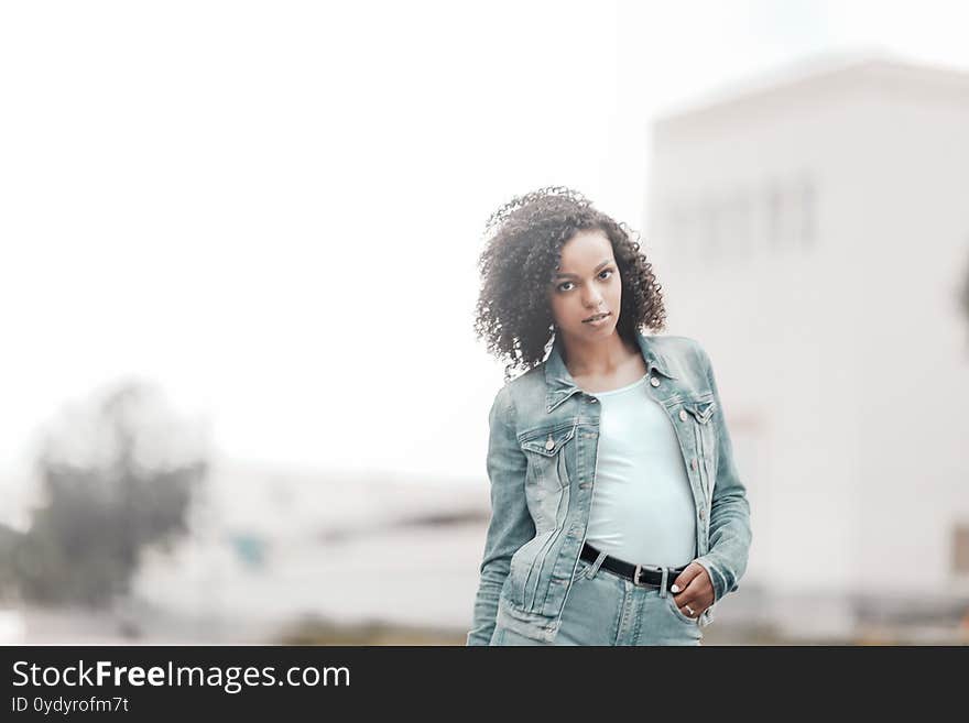 Attractive dark skin girl portrait. City hipster young woman walking on street