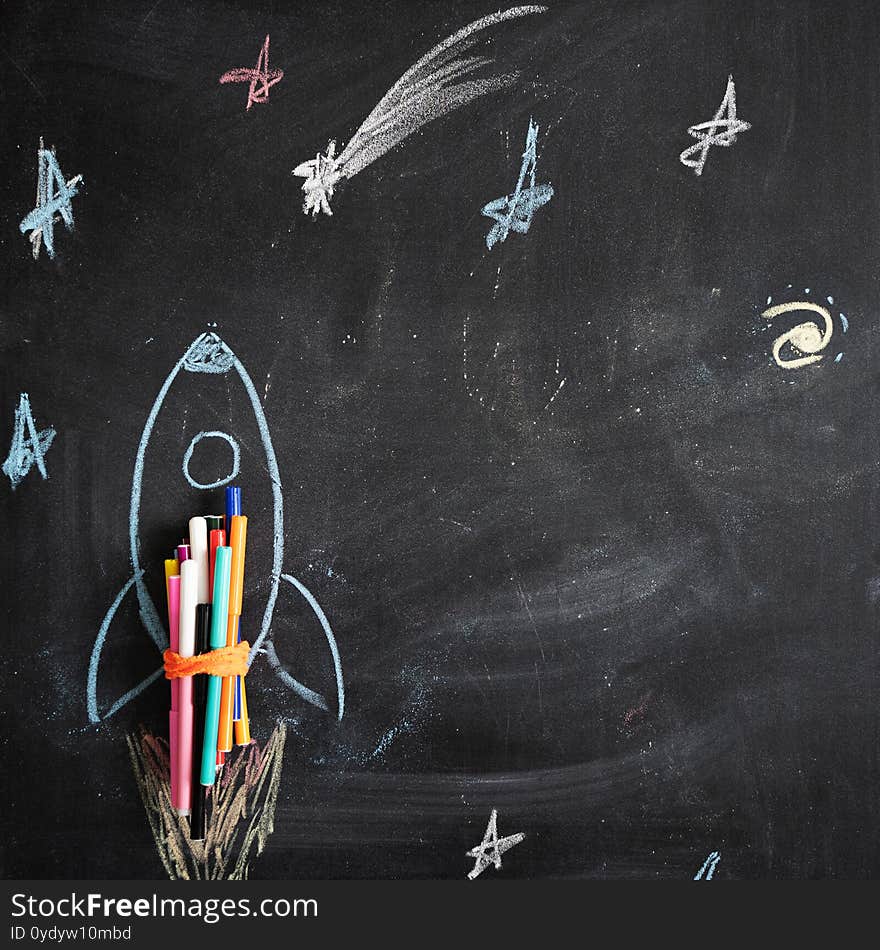 Chalk drawing of a rocket on the background of blackboard. Back to school