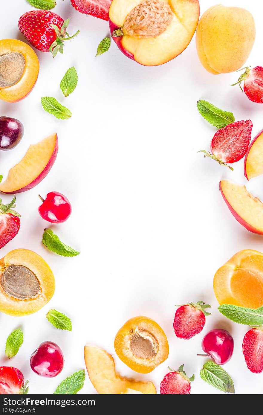 Summer background with fresh fruits and berries on white background. Set of various seasonal fruit and berry  - strawberry, apricots, peach slices, cherry, mint. Flat lay. Summer fruits concept