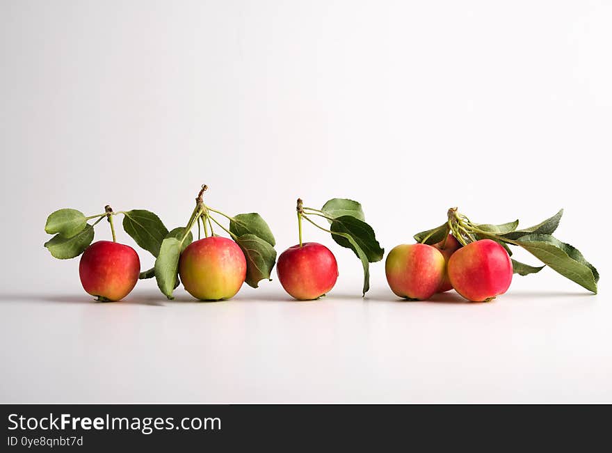 Red and yellow ripe apples with leaves on a light background. horizontal orientation. No people. Red and yellow ripe apples with leaves on a light background. horizontal orientation. No people.