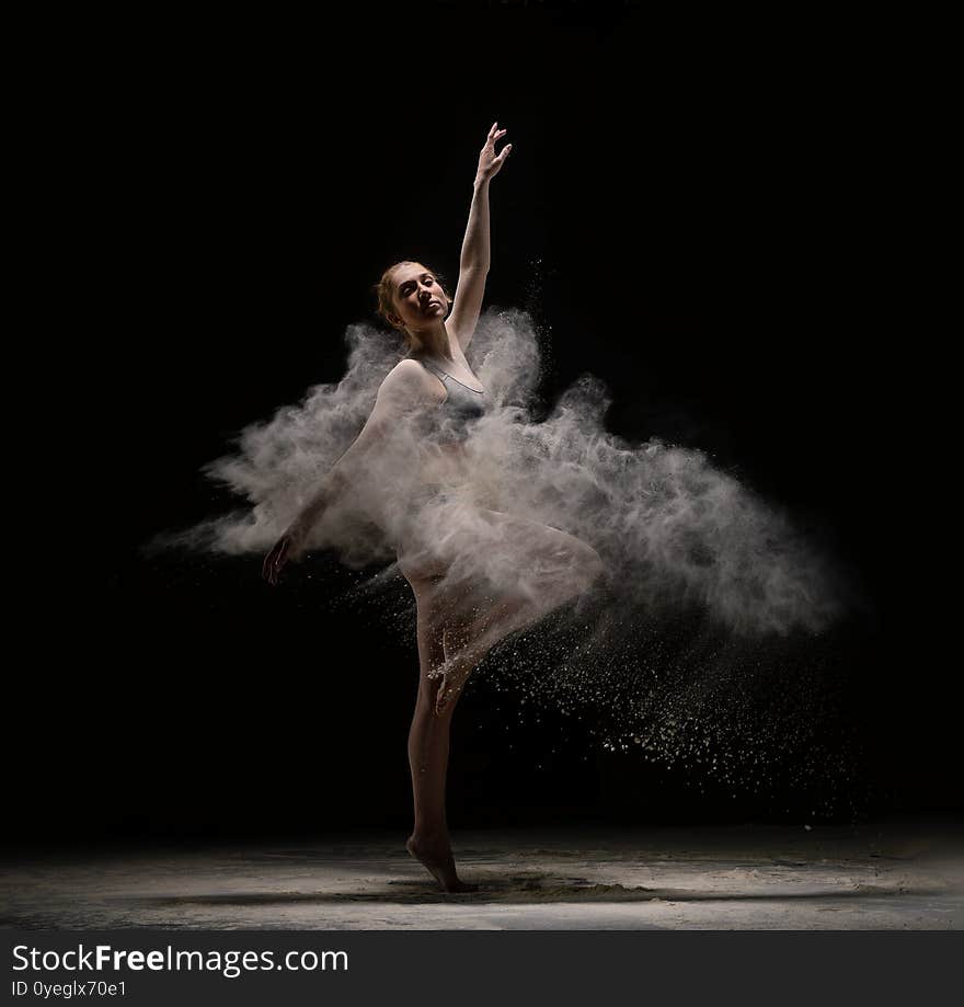 Slim female dancer throwing dust in air