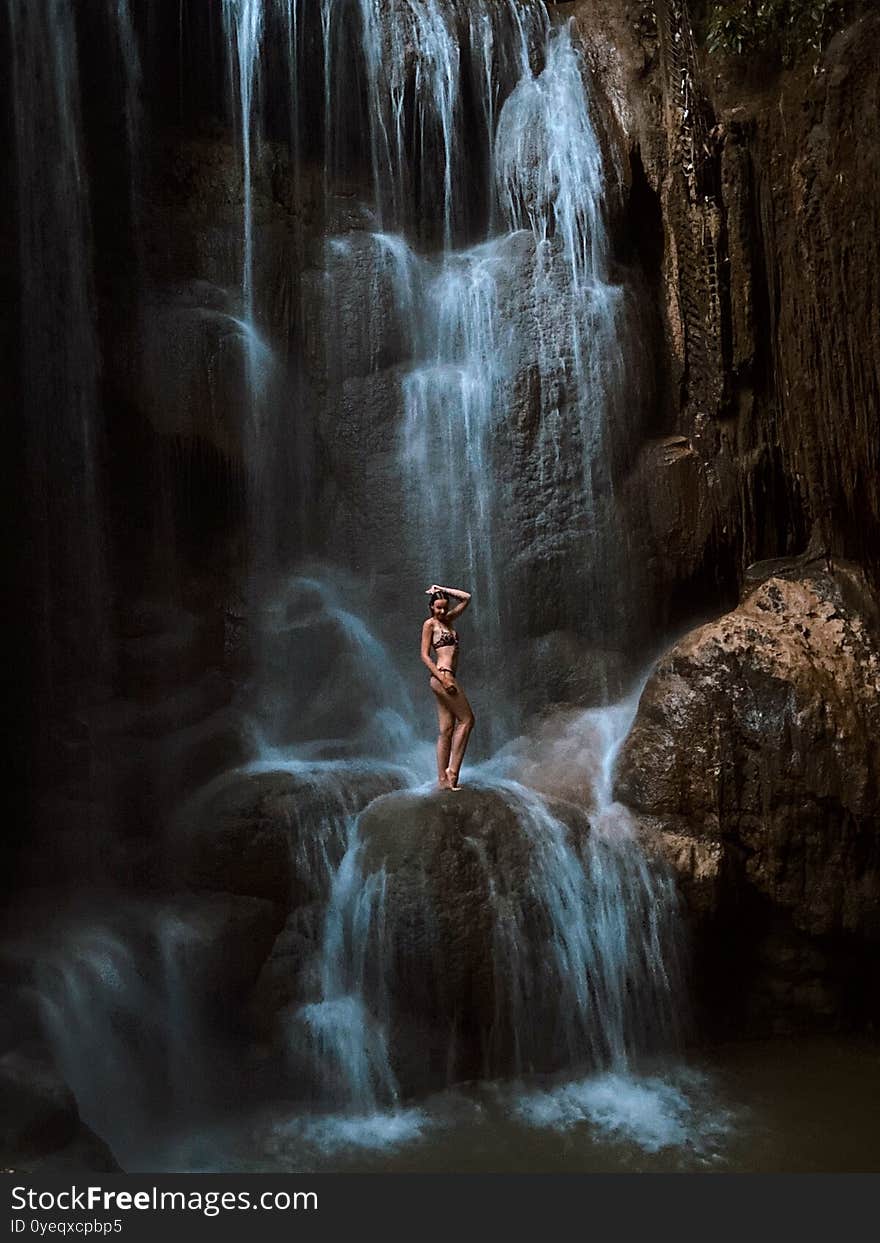 Woman Standing On Rock. Waterfall Water Flowing.