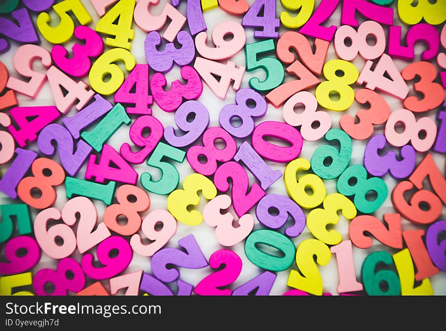 Bright multicolored background of wooden numbers from zero to nine. Top view, abstract colorful texture with numbers. Concept: back to school, math