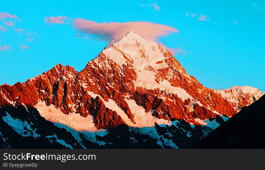 Orange Sunset And Light White Snow On Mountain With Blue Sky And Fantastic Nature