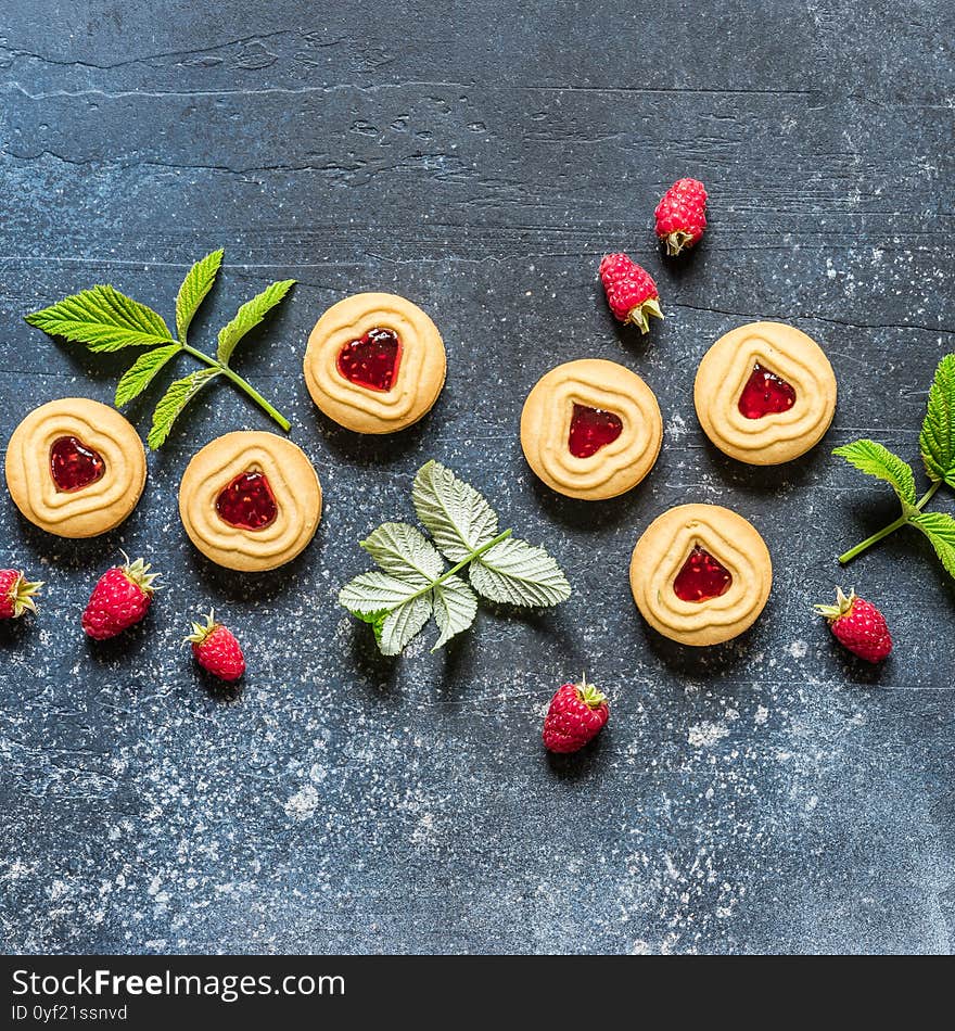 Shortbread Butter Cookies with Raspberry Jam Filling Center, Fresh Berries and Leaves, Blue Concrete Background, square, copy space for your text. Shortbread Butter Cookies with Raspberry Jam Filling Center, Fresh Berries and Leaves, Blue Concrete Background, square, copy space for your text