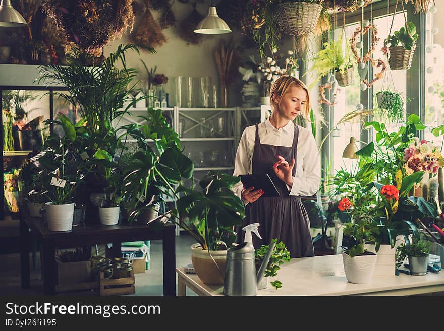 Elegant Worker Studies New Flower Before Selling.