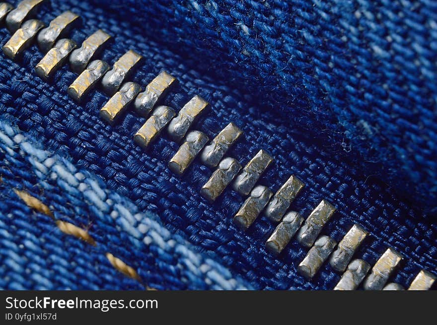 Metal zipper on blue jeans. macro