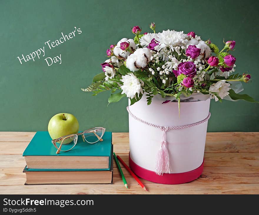 Stack of books and a bouquet of flowers on artistic background. Teacher`s Day card