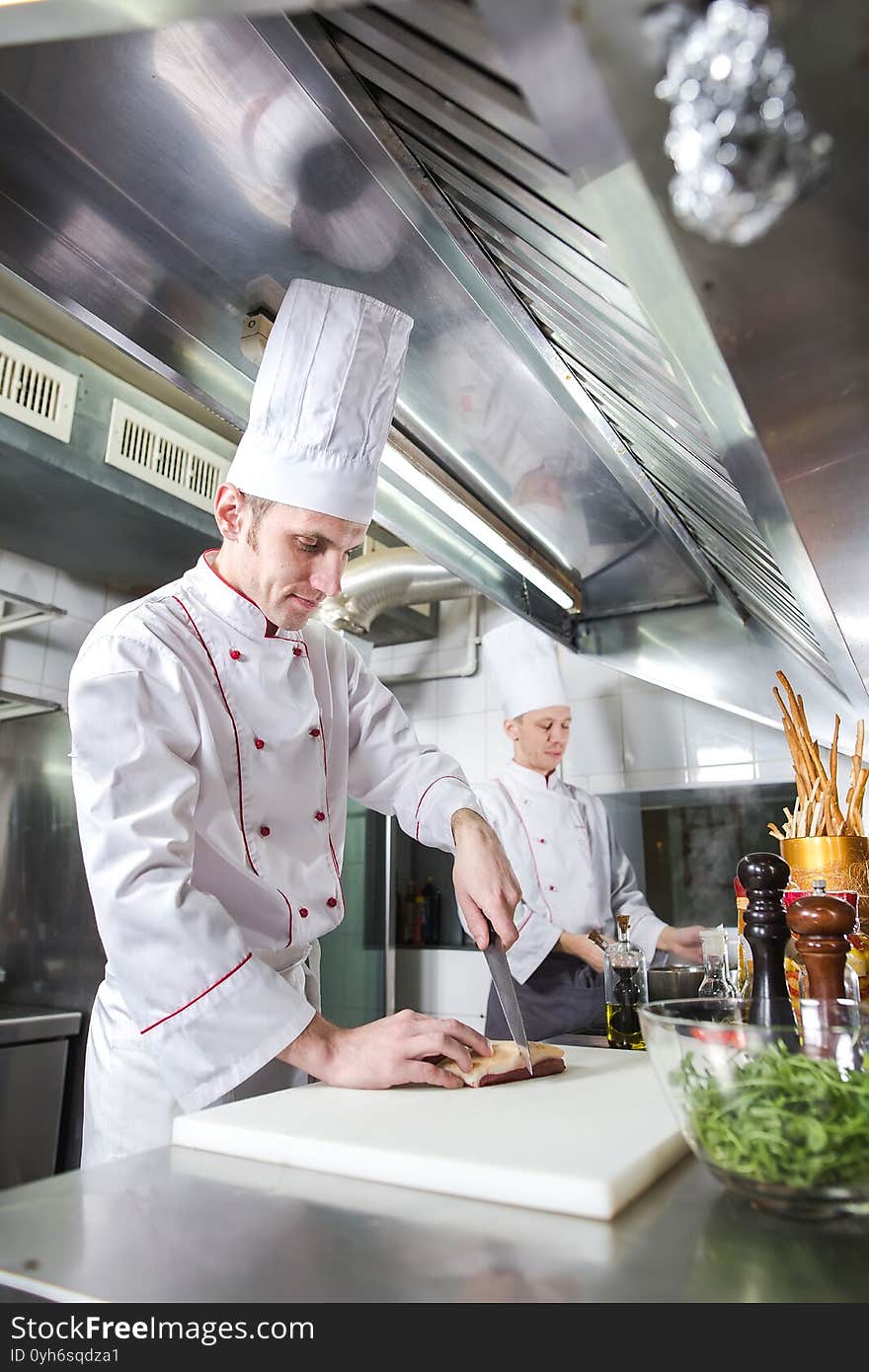 Chef Cutting Meat On Chopping Board, Professional Cook Holding Knife And Cutting Meat In Restaurant.