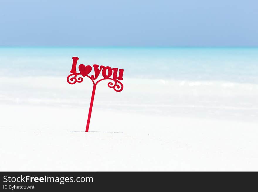 I LOVE YOU message decorated on white sandy beach, wooden words on sand close to sea, Valentines day background