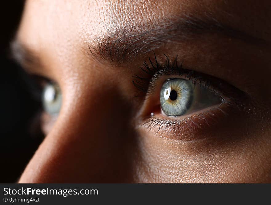 Amazing female green and blue colored eyes in low light technique close-up. Amazing female green and blue colored eyes in low light technique close-up