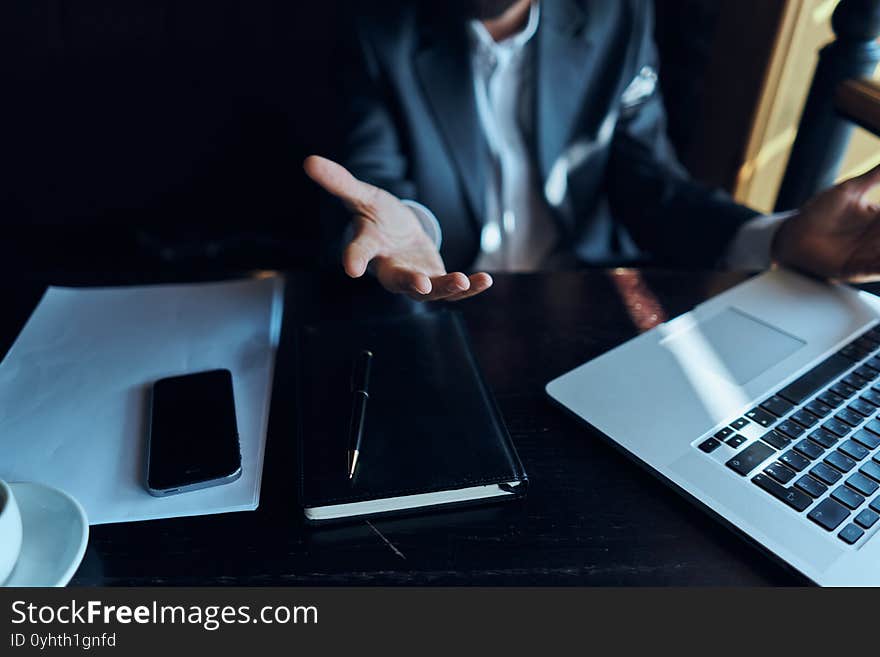 A business man in a suit is sitting in a cafe or with a laptop the work is an official