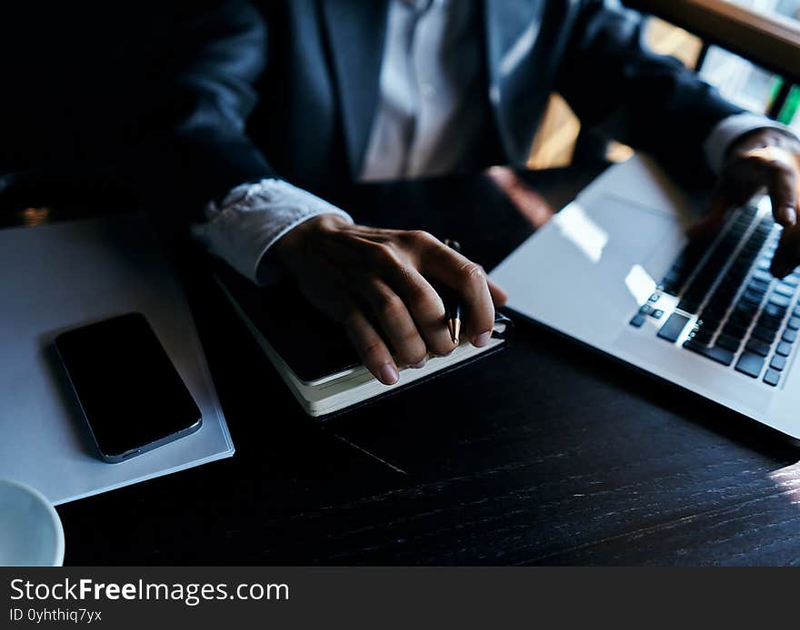 A business man in a suit is sitting in a cafe or with a laptop the work is an official. High quality photo