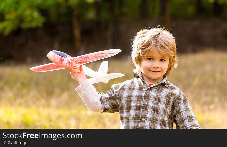 Happy boy play airplane. Little boy with plane. Little kid dreams of being a pilot. Child playing with toy airplane. Happy child playing outdoors.