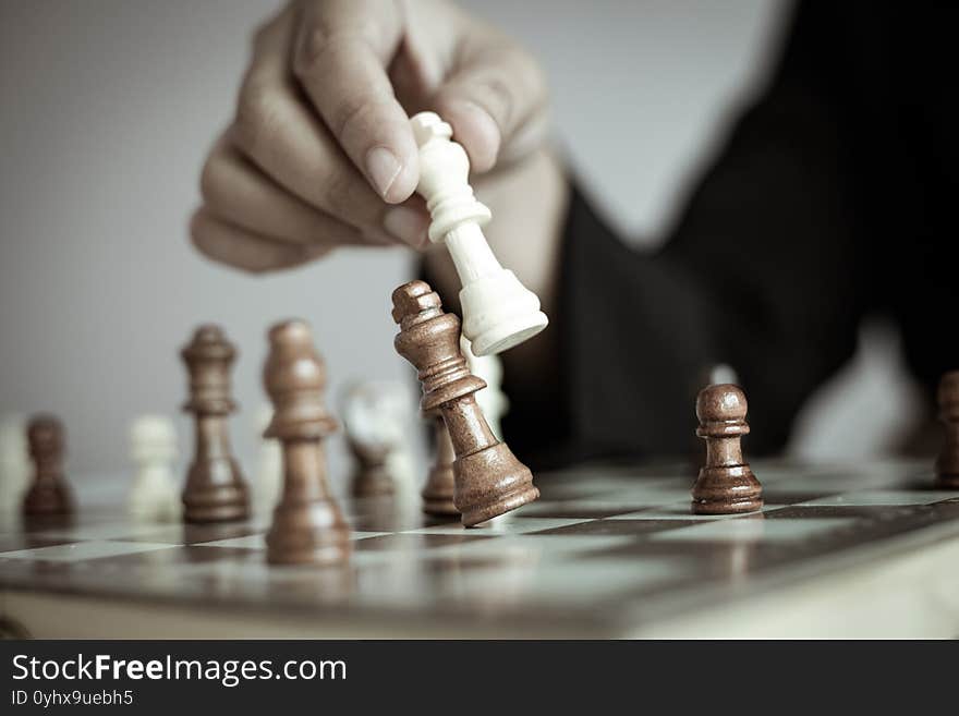 Close up shot hand of business woman playing the chess board to win by killing the king of opponent metaphor business competition winner and loser select focus shallow depth of field with vintage tone processed