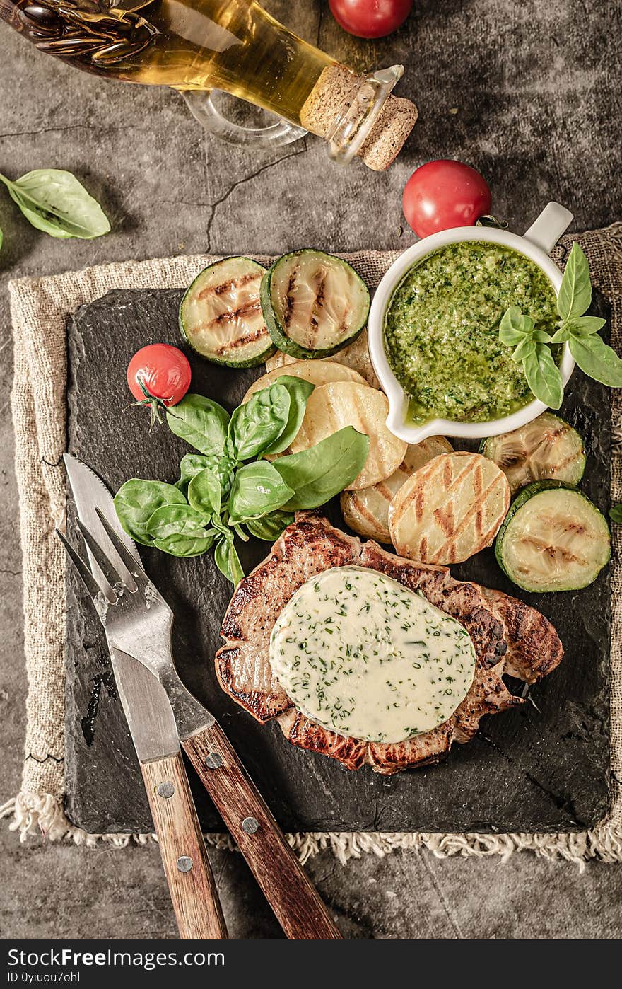 Grilled steak with herbs butter, grilled vegetable with garlic. Grilled steak with herbs butter, grilled vegetable with garlic