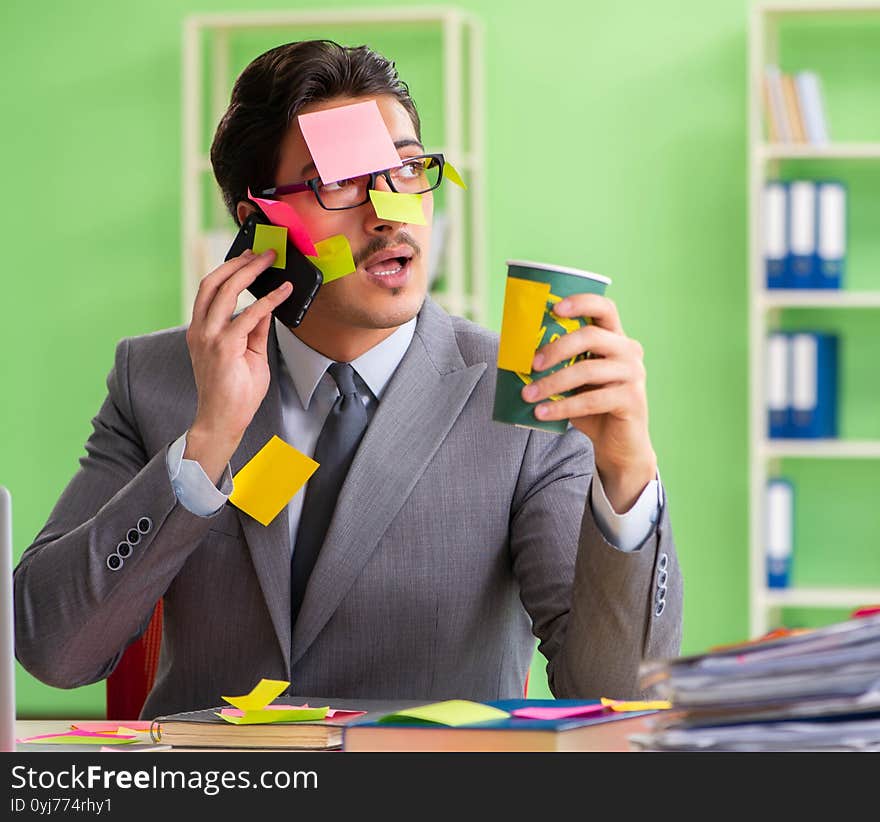 Businessman unhappy with many conflicting priorities sitting in the office