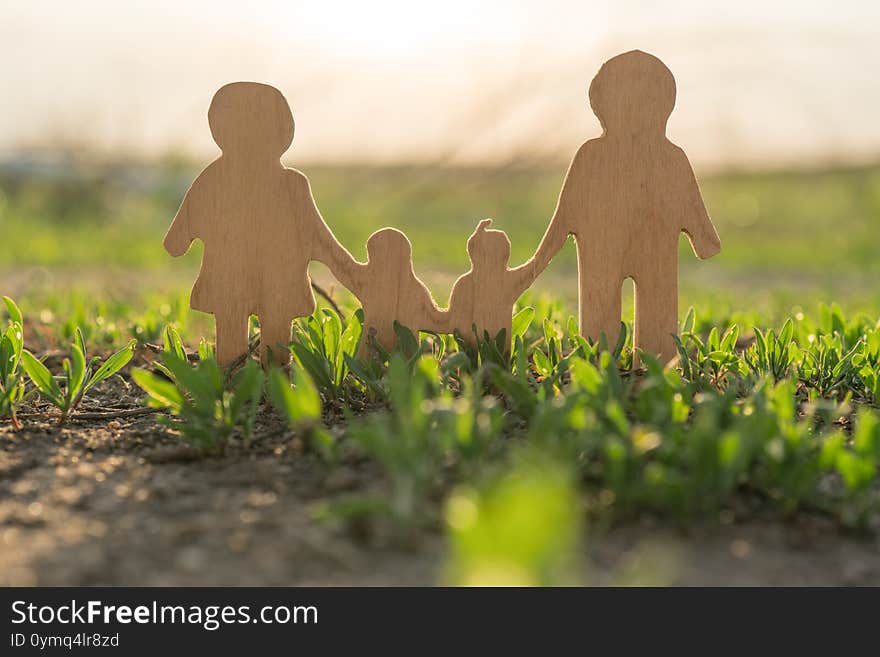 Figures Of A Family With Children Outdoors Nature. Games On The Grass