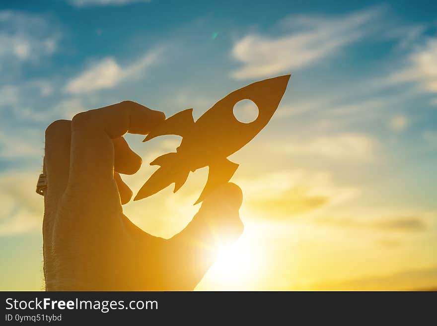 Launch Rocket In Businessman Hand On Sunset Sky Background. Business Concept Idea, Partnership