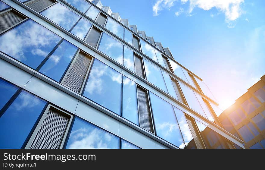 Modern office building wall made of steel and glass with blue sky. Modern office building wall made of steel and glass with blue sky.