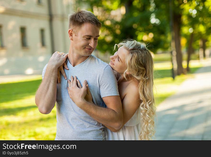 Happy to be together. Portrait of beautiful young loving couple smiling look at each other while standing outdoors. Happy to be together. Portrait of beautiful young loving couple smiling look at each other while standing outdoors