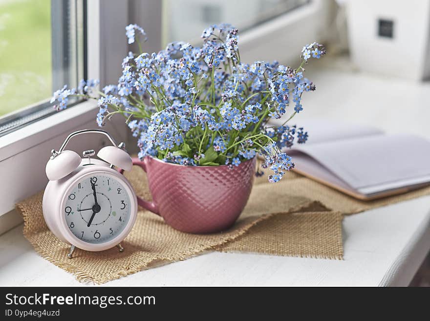 Notebook and glasses, spring flowers on wooden rustic windowsill. Photo toned, selective focus. Cozy home still life