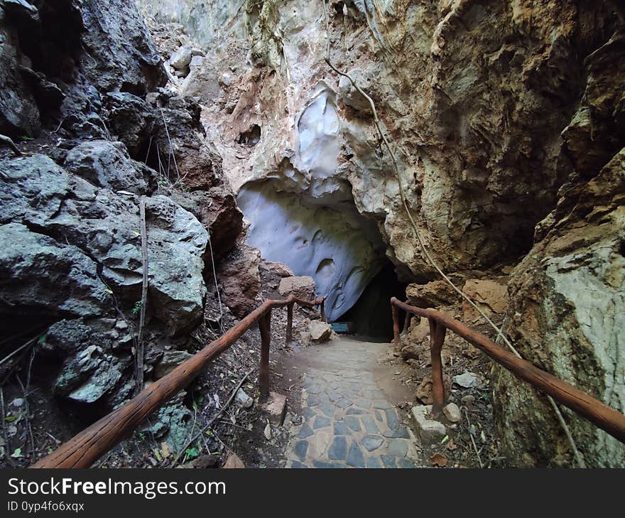 Horizontal photo of cave entrance with handrail in Thaailand.