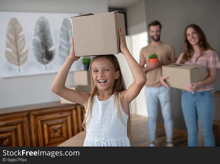 Cute Long-haired Girl Holding A Cardboard On Her Head And Smiling