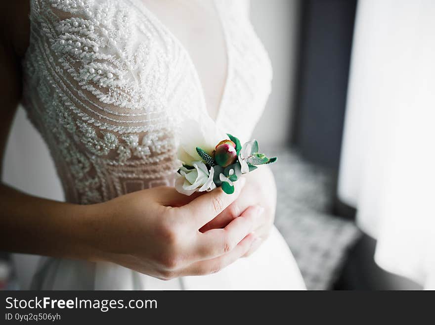 Beautiful luxury bride in elegant white dress holds bouquet of flowers in the hands